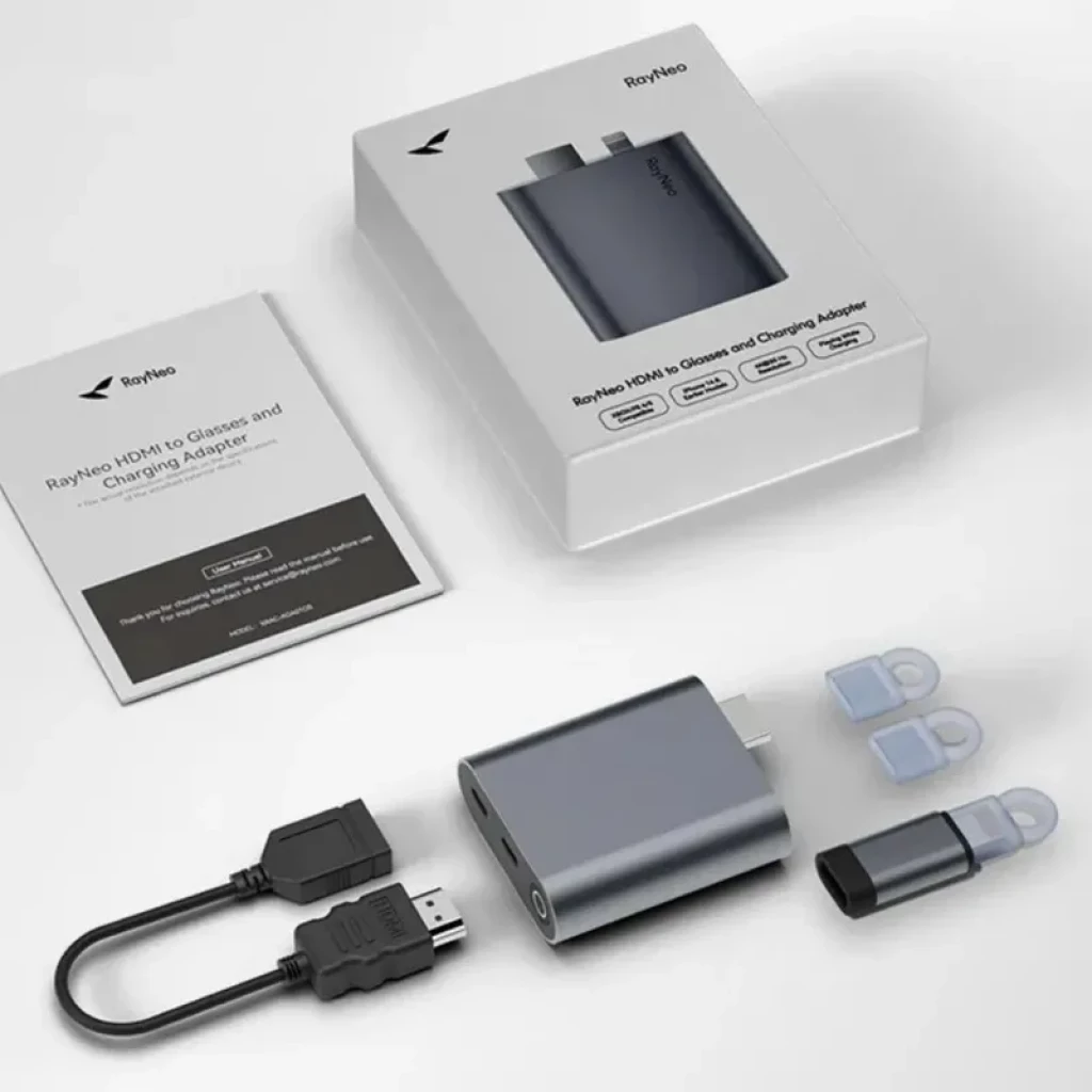 Adaptador HDMI a USB-C para cargar las gafas AR RayNeo, compacto en aluminio gris. Incluye cable HDMI corto, tapa protectora, repuestos y manual.