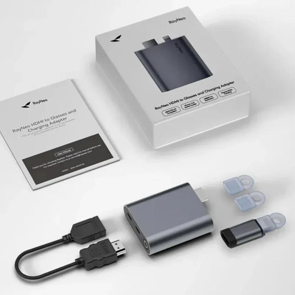 Adaptador HDMI a USB-C para cargar las gafas AR RayNeo, compacto en aluminio gris. Incluye cable HDMI corto, tapa protectora, repuestos y manual.