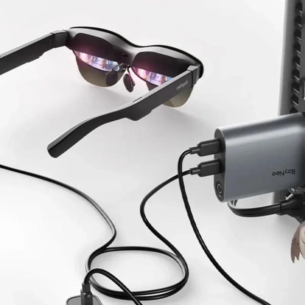 Adaptador HDMI a USB-C compacto en gris con dos puertos y cable, diseñado para cargar y conectar las gafas AR RayNeo mientras se usan