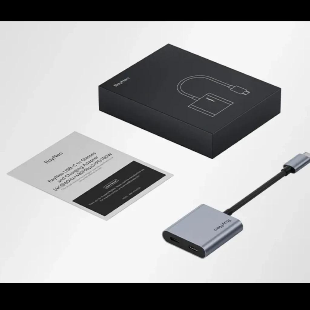 Adaptateur de charge USB-C pour lunettes AR RayNeo, boîtier compact en aluminium gris, câble court noir, port USB-C et indicateur, livré avec notice et