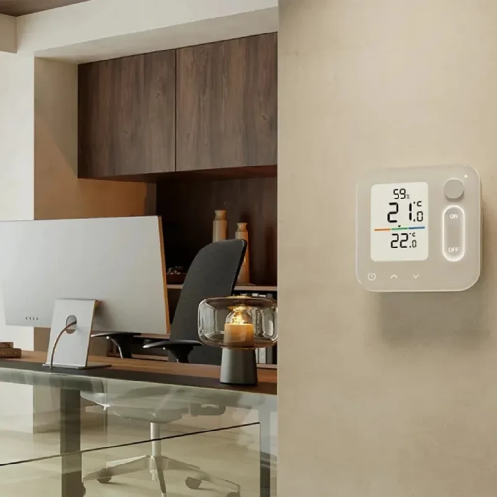 Switchbot Home Air Conditioning Panel montado en pared con pantalla LCD a color, indicadores de humedad y temperatura, perilla lateral y botones ON OFF