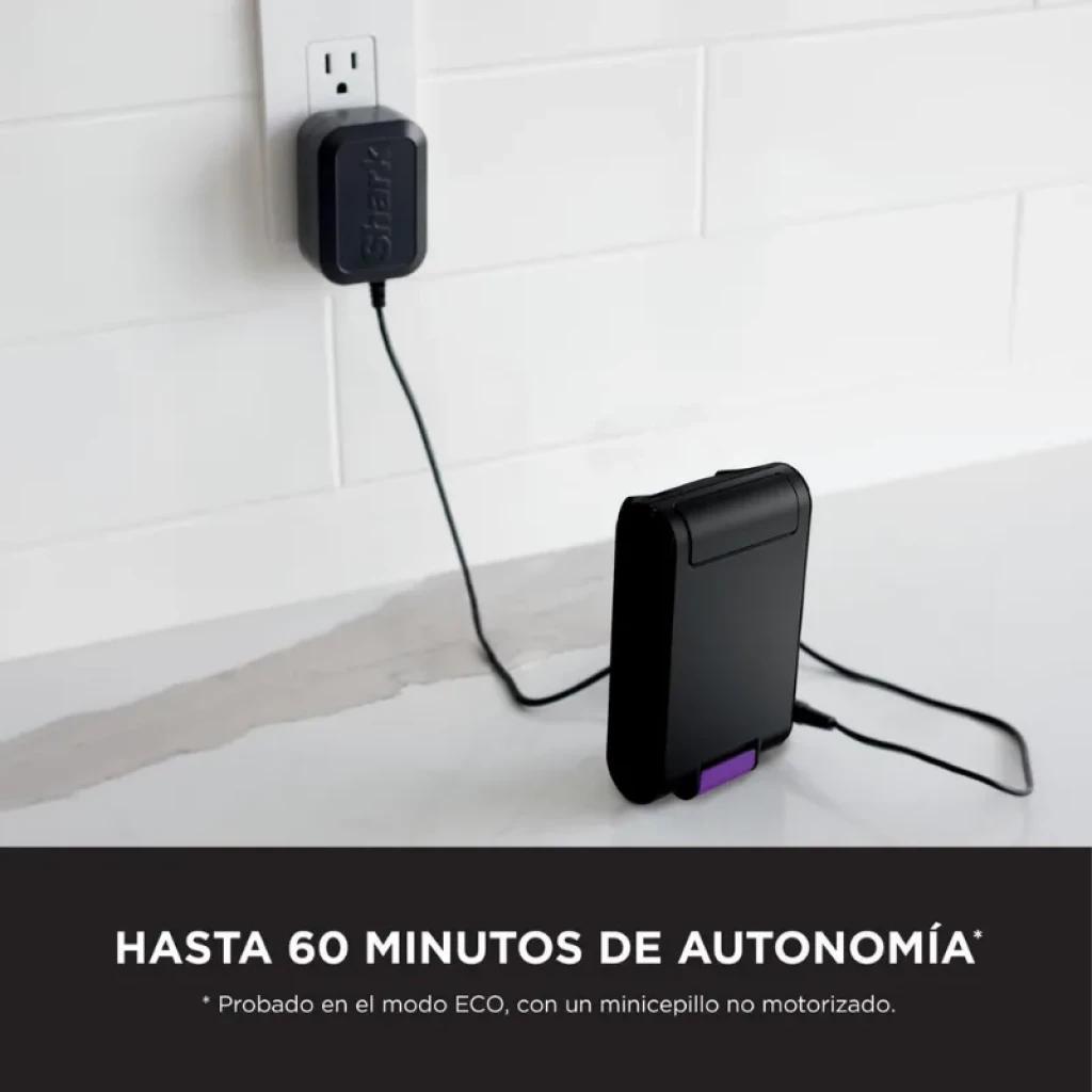 Batterie amovible Shark IW3612EU en charge, couleur noire avec détails violets, connectée à un adaptateur mural ; autonomie promise jusqu'à 60 minutes