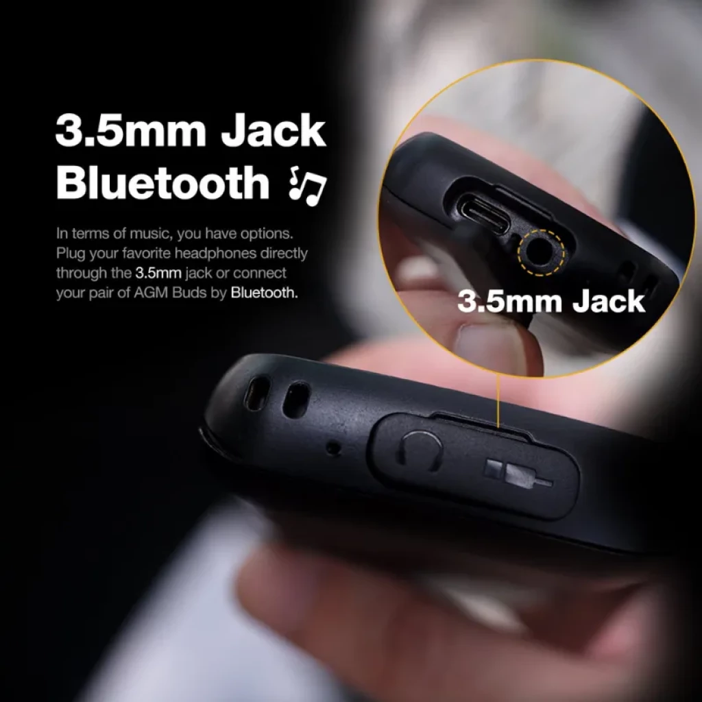 Conector de 3.5 mm y puerto USB en teléfono resistente AGM M9; detalle ampliado del jack para auriculares, compatible con Bluetooth y diseño robusto negro