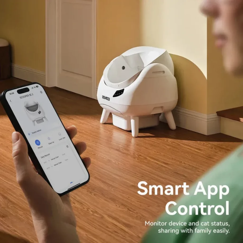 Arenero autolimpiable blanco con tapa abierta, diseño esférico sobre patas, control por app en smartphone, pantalla frontal y entrada amplia para el gato