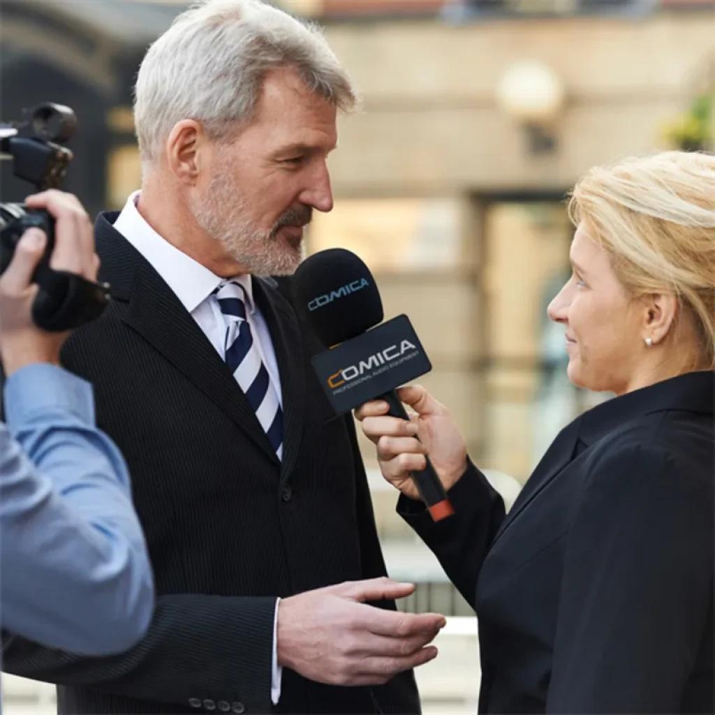 Comica HR-WM Transmisor UHF de mano con cápsula supercardioide, cuerpo negro, rejilla metálica, logo visible en espuma antiviento, ideal para entrevistas