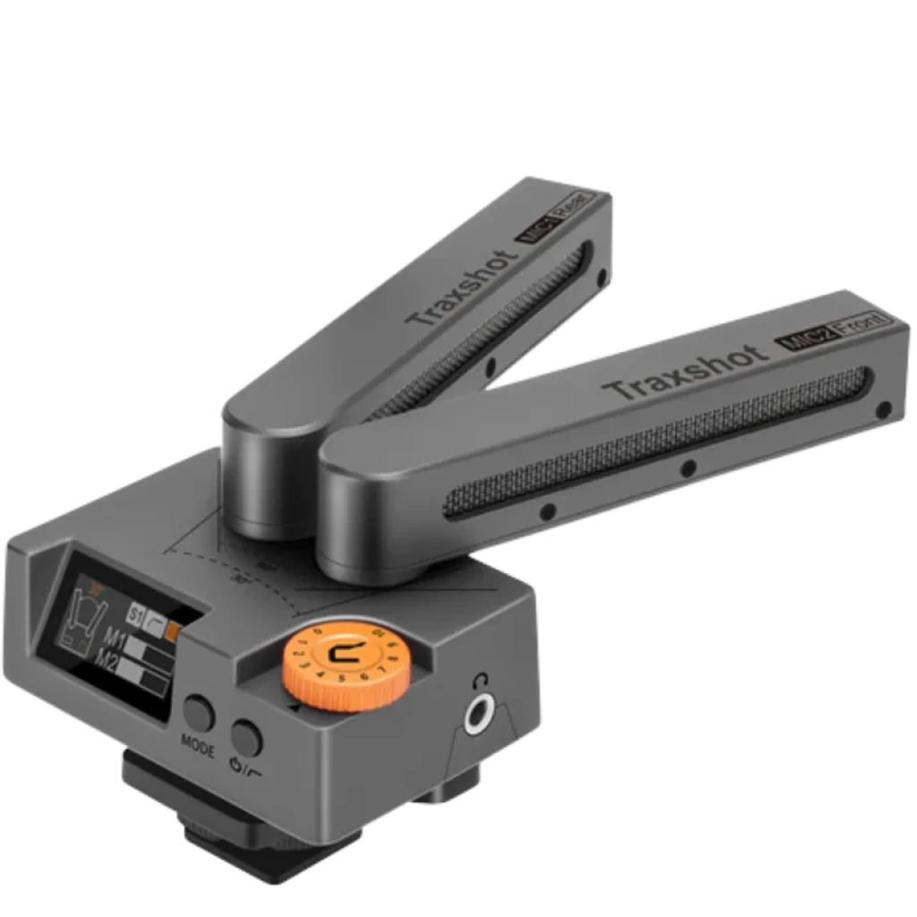 Comica Traxshot microfone shotgun cinza com dois braços ajustáveis, ecrã OLED lateral, dial laranja e porta fria inferior; design modular multimodo