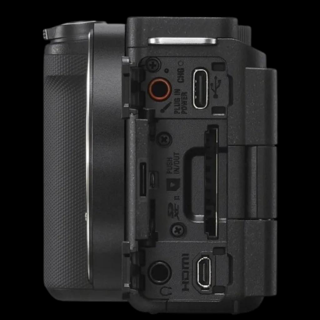 Lateral de la Sony ZV-E10 II con puertos HDMI, USB-C, micrófono y auriculares, tapa abierta y agarre texturizado en cuerpo compacto para vlogging 4K 10 bits