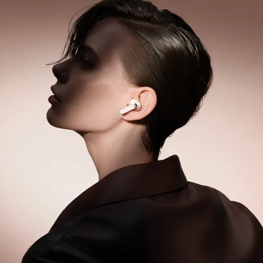 Auricular Huawei FreeBuds Pro 5 gris en oreja, diseño intrauditivo con vástago corto y acabado metálico, ajuste ergonómico y perfil minimalista elegante