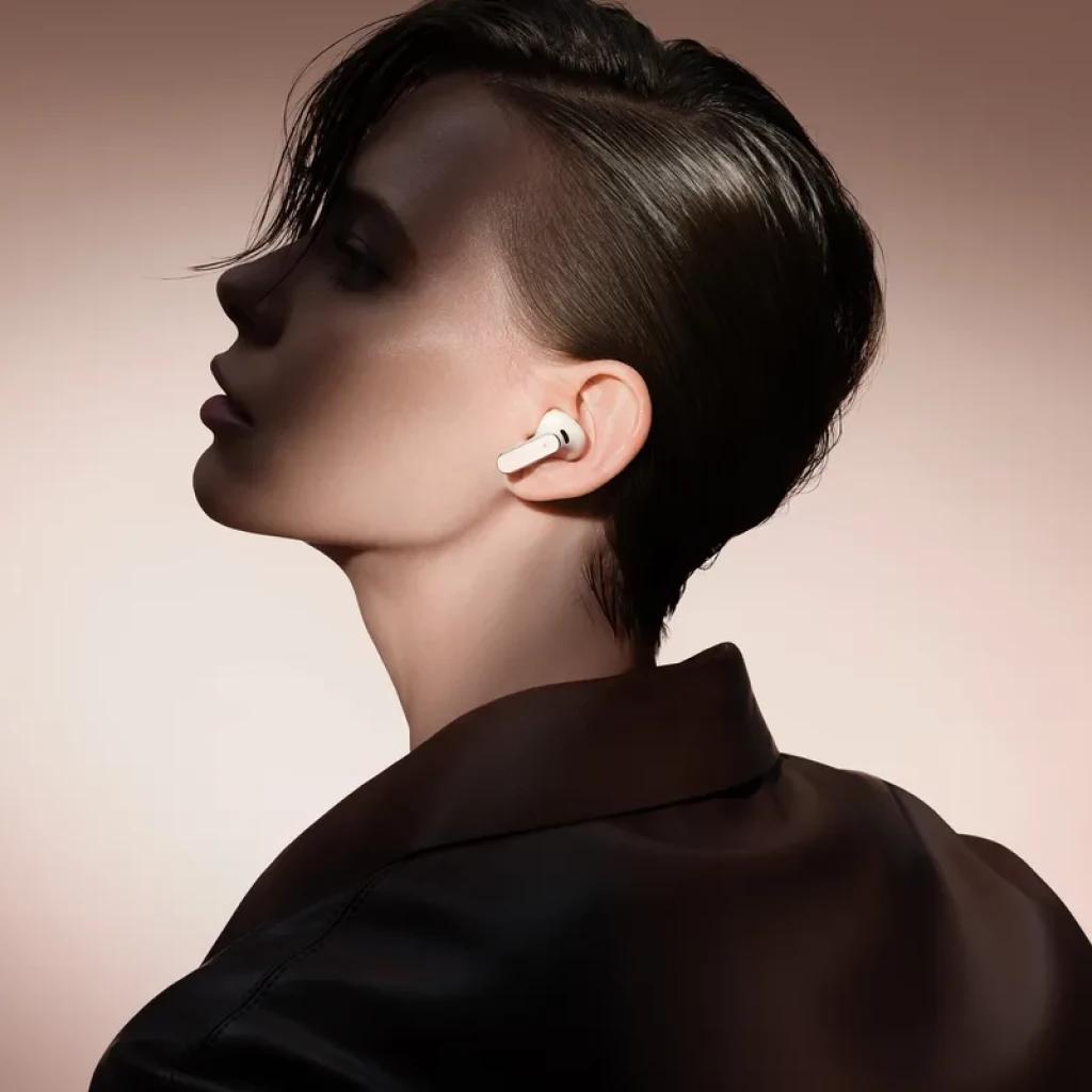 Auricular Huawei FreeBuds Pro 5 gris en oreja, diseño intrauditivo con vástago corto y acabado metálico, ajuste ergonómico y perfil minimalista elegante