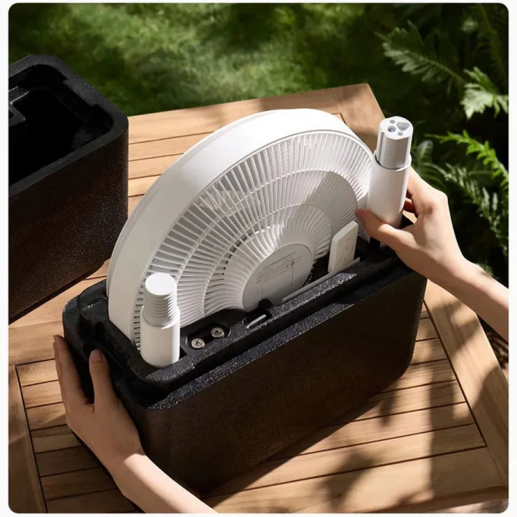 Ventilateur sur pied blanc démonté dans un coffret mousse, grille fine, pièces modulaires USB C visibles, design fin et portable pour montage facile