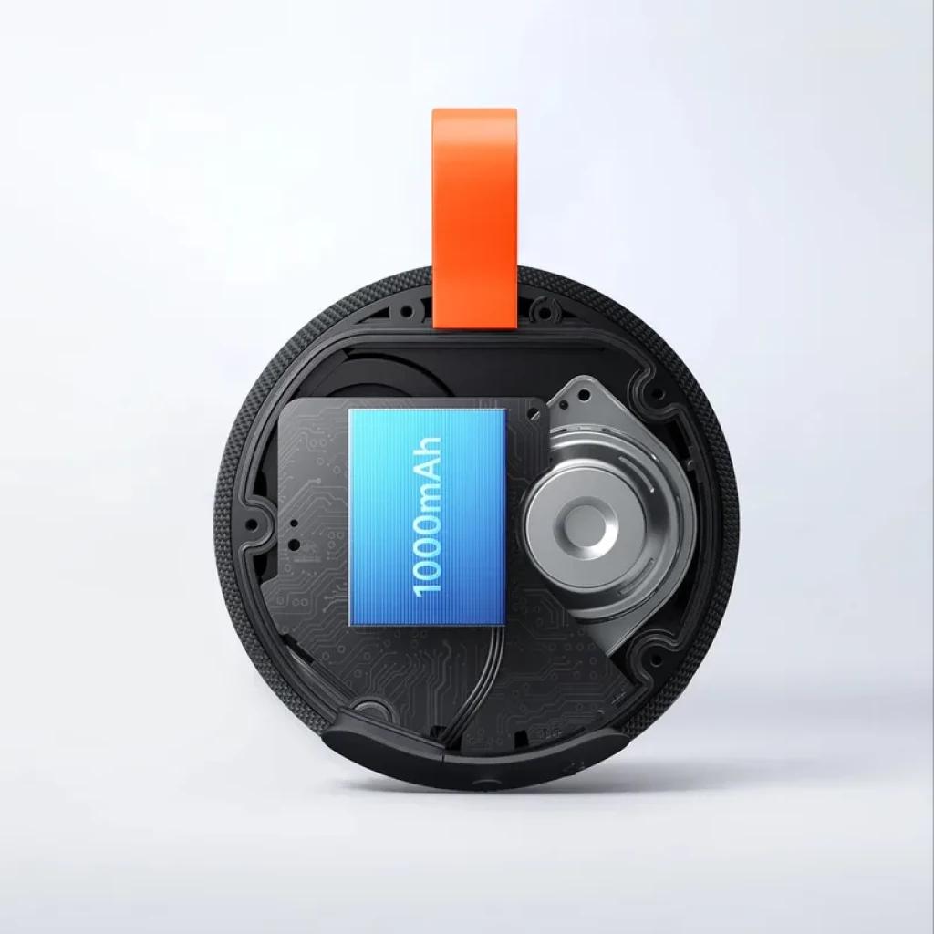 Componente interno del Xiaomi Bluetooth Speaker Essential 5W: batería 1000 mAh visible, driver circular, circuito impreso y correa naranja IP66 en carcasa
