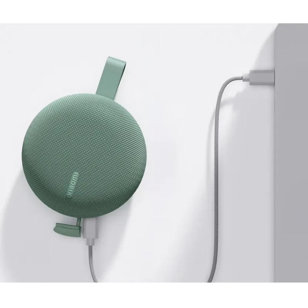 Altavoz portátil Xiaomi verde con cuerpo redondo tejido, correa de silicona, carga por cable trenzado USB, rejilla fina y diseño compacto resistente IP66