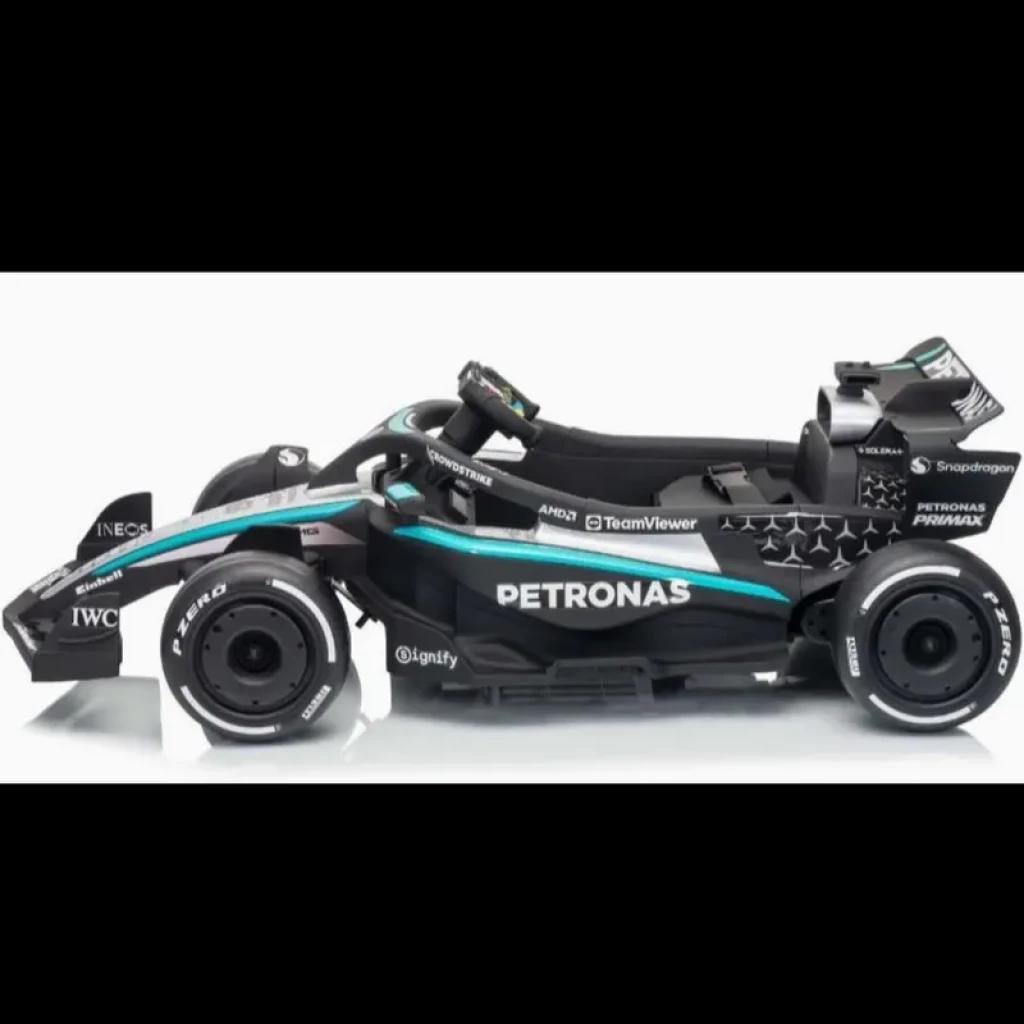 Coche eléctrico infantil estilo F1 Mercedes-AMG Petronas 12V, color negro con detalles turquesa y plateados, llantas anchas, alerón trasero y mando parental