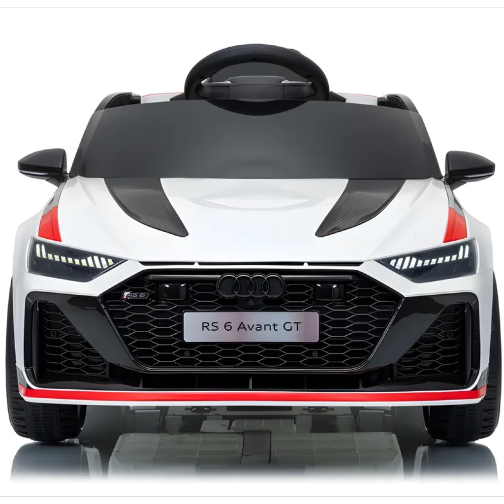 Frontal del Audi RS 6 Avant GT infantil: carrocería blanca con detalles rojos, parrilla hexagonal negra, faros LED afilados y capó con acabado tipo fibra de
