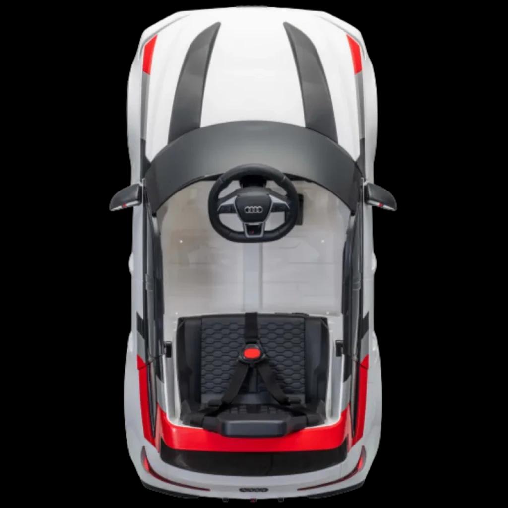 Coche eléctrico infantil Audi RS 6 Avant GT blanco con franjas negras y rojas, asiento acolchado con arnés, volante Audi y parabrisas transparente