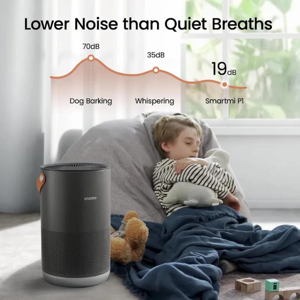 Smartmi Air Purifier P1 Gris Oscuro con diseño cilíndrico, rejilla 360°, asa naranja y luz superior, compacto y silencioso junto a un sofá y manta