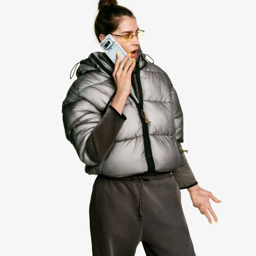 Mulher segurando Nothing Phone 4a 5G branco com traseira translúcida e Interface Glyph iluminada; câmera dupla e capa transparente em destaque