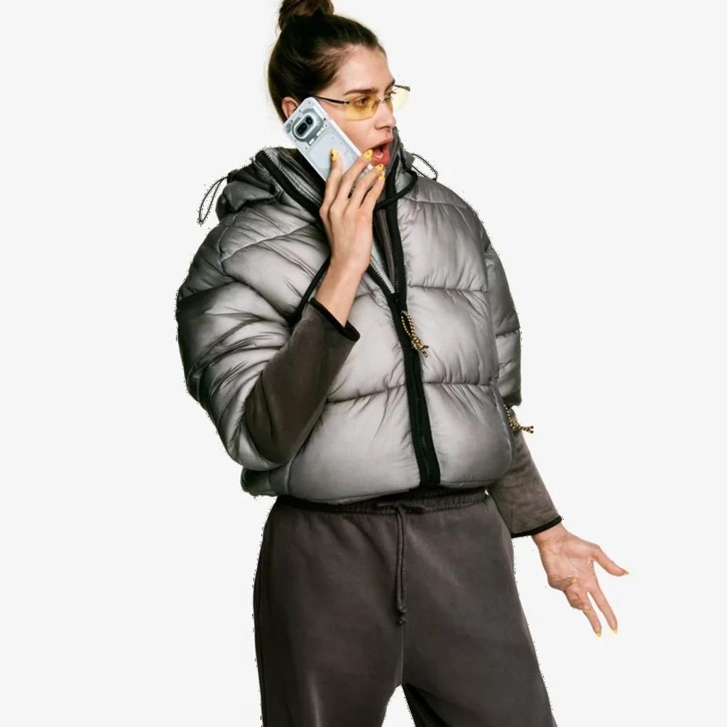 Mulher segurando Nothing Phone 4a 5G branco com traseira translúcida e Interface Glyph iluminada; câmera dupla e capa transparente em destaque