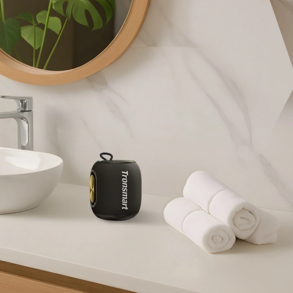 Altavoz portátil Tronsmart T8 Mini negro, compacto con asa, laterales dorados, rejilla frontal y logo visible; diseño resistente IPX7 para uso en baño o