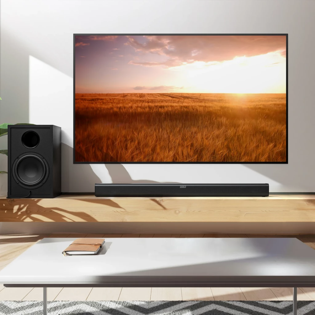 Barra de sonido Tribit Soundbar 2.2 negra bajo TV, diseño minimalista con rejilla frontal y controles superiores; subwoofer lateral independiente en negro