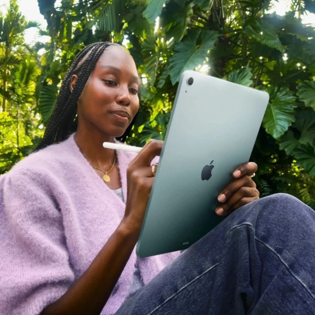 Apple iPad Air M4 11 128GB WiFi Gris, trasera en aluminio gris con logo Apple, cámara única en esquina, usado con Apple Pencil en exterior tropical