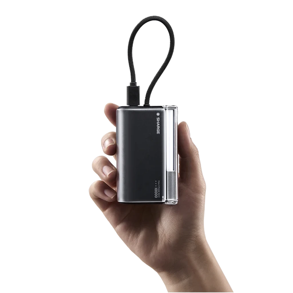 Power bank compacto negro con lateral transparente, capacidad 10000mAh, salida 45W y cable USB-C integrado trenzado, diseño portátil en mano