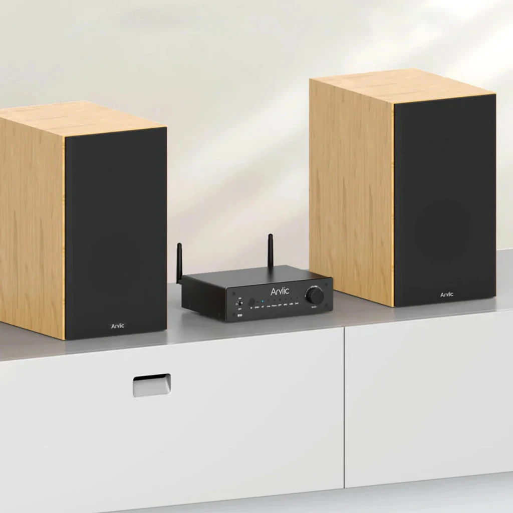 Arylic B50 Amplificador Bluetooth 5.2 negro con antenas duales, panel frontal con perilla y botones, diseño compacto entre dos altavoces de madera clara