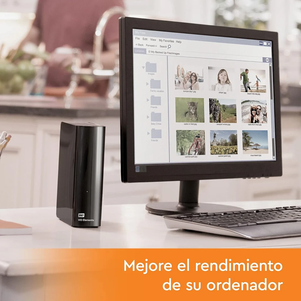 Disco duro externo WD Elements Desktop 20 TB negro, carcasa brillante vertical con logo WD, puerto USB 3.2, junto a monitor y teclado en escritorio