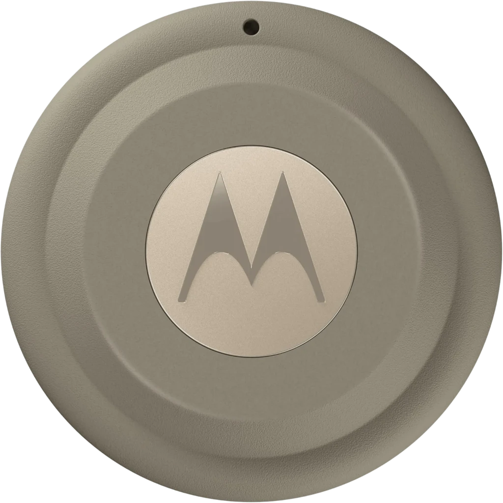 Motorola Moto Tag 2.0 PANTONE Laurel Oak en beige verdoso, forma circular, logo M central metálico, orificio superior, acabado mate con bordes en relieve