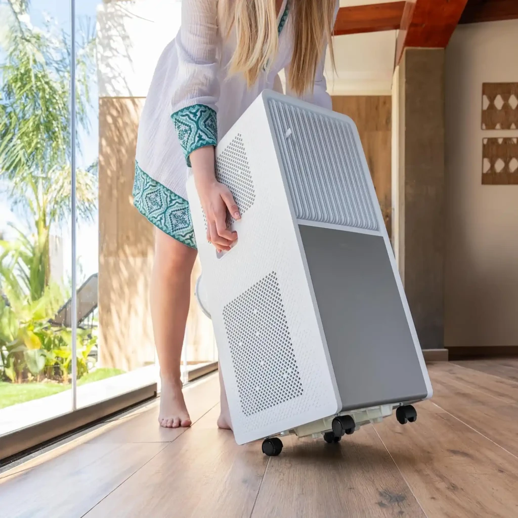 Climatiseur mobile blanc compact avec poignées latérales et roulettes, grandes grilles d’aération, design moderne pour pièces jusqu’à 25 m²