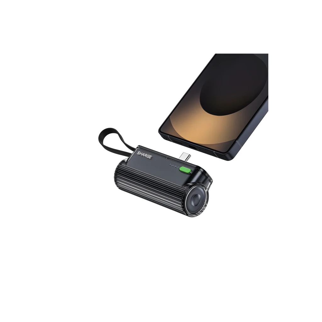Power bank Sharge Flow Mini Negro 5000mAh y 22.5W con cable USB-C integrado, diseño compacto estriado, correa lateral y LEDs de estado, cargando un móvil