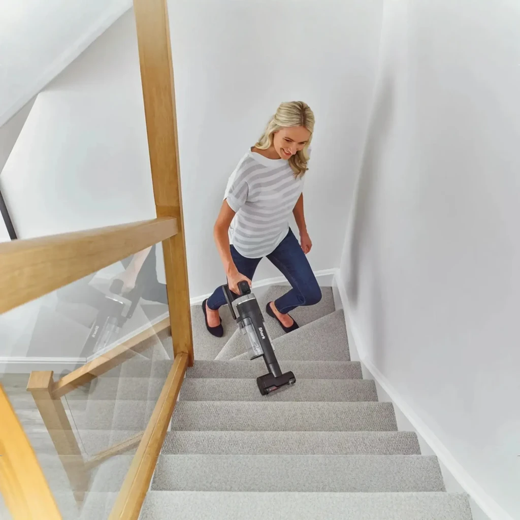 Aspiradora Escoba Shark Stratos IZ400EUT sin cable, ligera y ergonómica, usada en modo de mano para limpiar escaleras alfombradas con cepillo motorizado