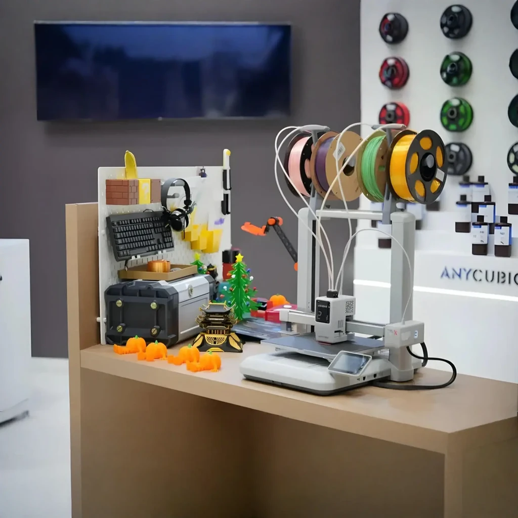 Impresora 3D FDM Anycubic Kobra X ACE GEN 2 con 4 bobinas multicolor, sistema multiextrusión, estructura robusta y base estable; entorno de taller técnico
