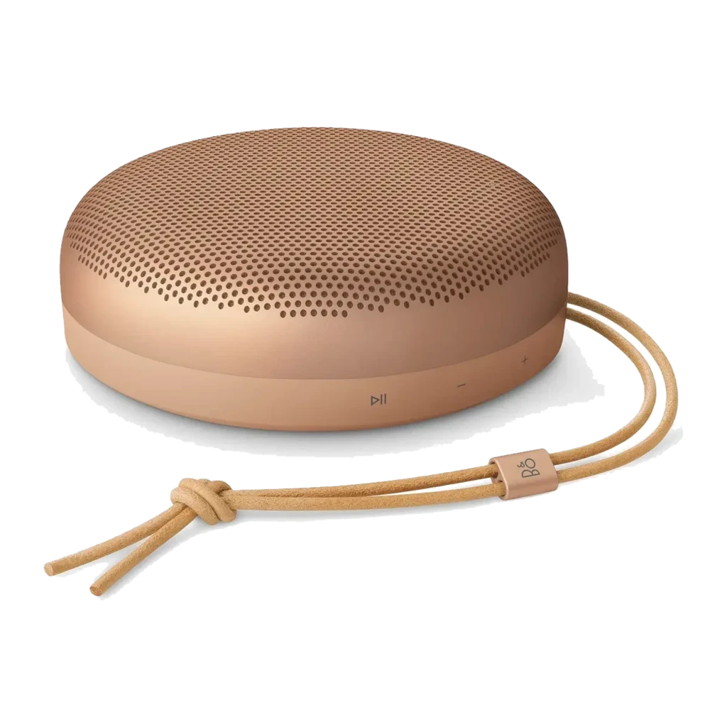 Bang & Olufsen Beosound A1 3rd Gen Honey Tone, vista en ángulo: forma circular, rejilla perforada y correa de cuero con logo