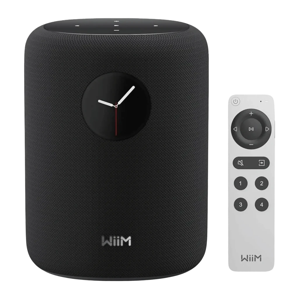 Wiim Sound negro, vista frontal: altavoz cilíndrico con pantalla de reloj analógico y mando a distancia blanco incluido