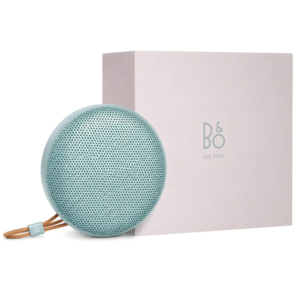 Bang & Olufsen Beosound A1 3ª Gen verde eucalipto, vista frontal con caja: altavoz circular con rejilla y correa de cuero
