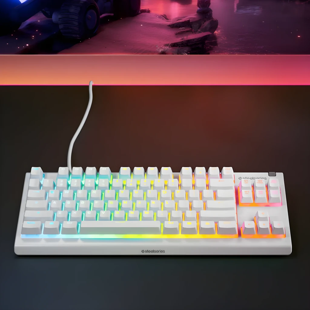 SteelSeries Apex 3 TKL blanco, vista en perspectiva: teclado sobre escritorio oscuro con iluminación RGB multicolor y cable