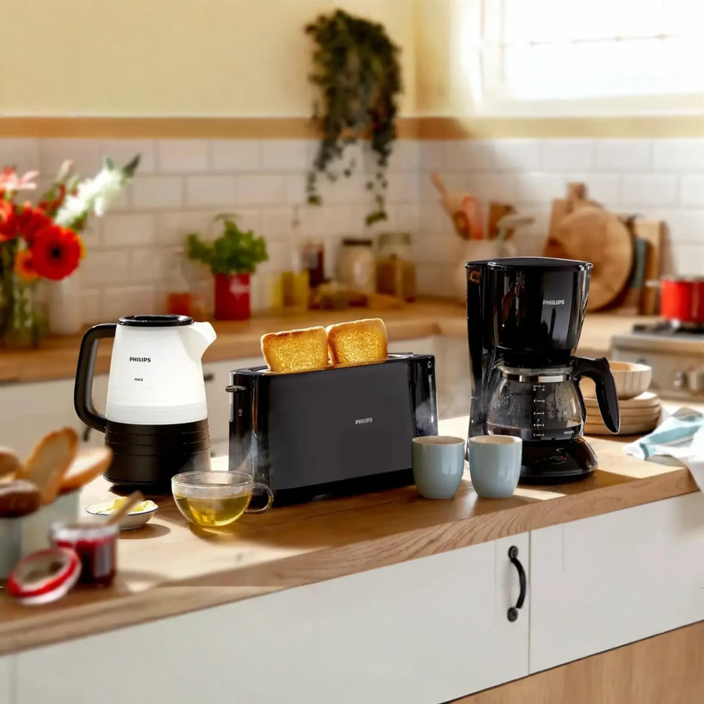 Philips Tostadora HD2590/90 Daily Collection negro, escena cocina: tostadora con tostadas junto a cafetera y hervidor Philips