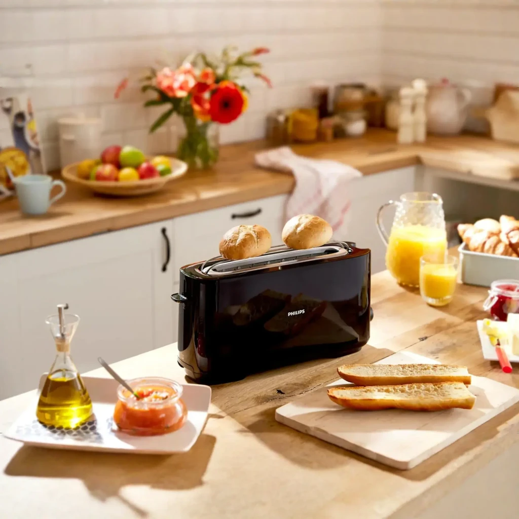 Philips Tostadora HD2590/90 Daily Collection negro, vista lifestyle: tostadora negra en cocina con panecillos y tostadas