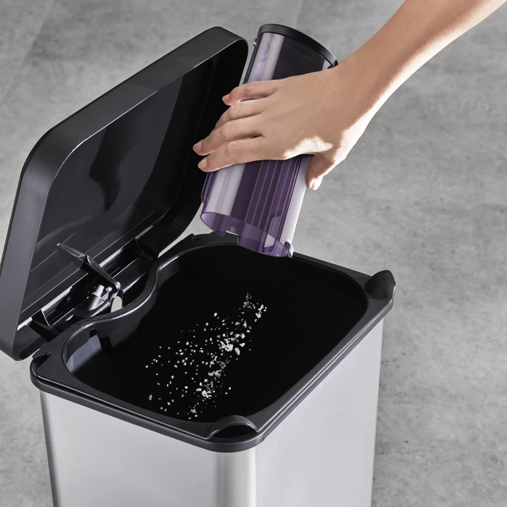 Rowenta X-Force Flex 9.60 Allergy RH2037WO Negro Púrpura, vaciado: mano vaciando depósito púrpura sobre cubo de basura