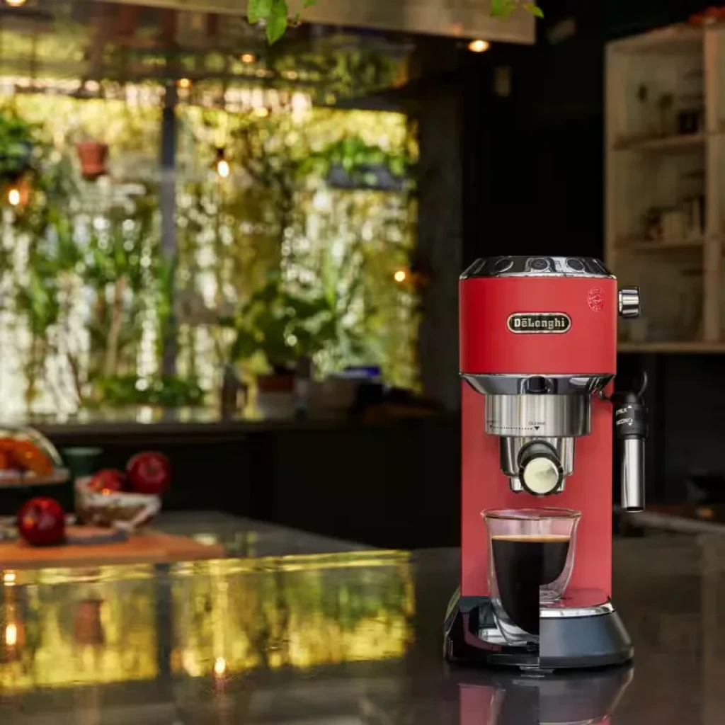 Cafetera DeLonghi EC 685.R roja, compacta y metálica, con portafiltro frontal, vaporizador lateral y bandeja recolectora; prepara un espresso en taza de