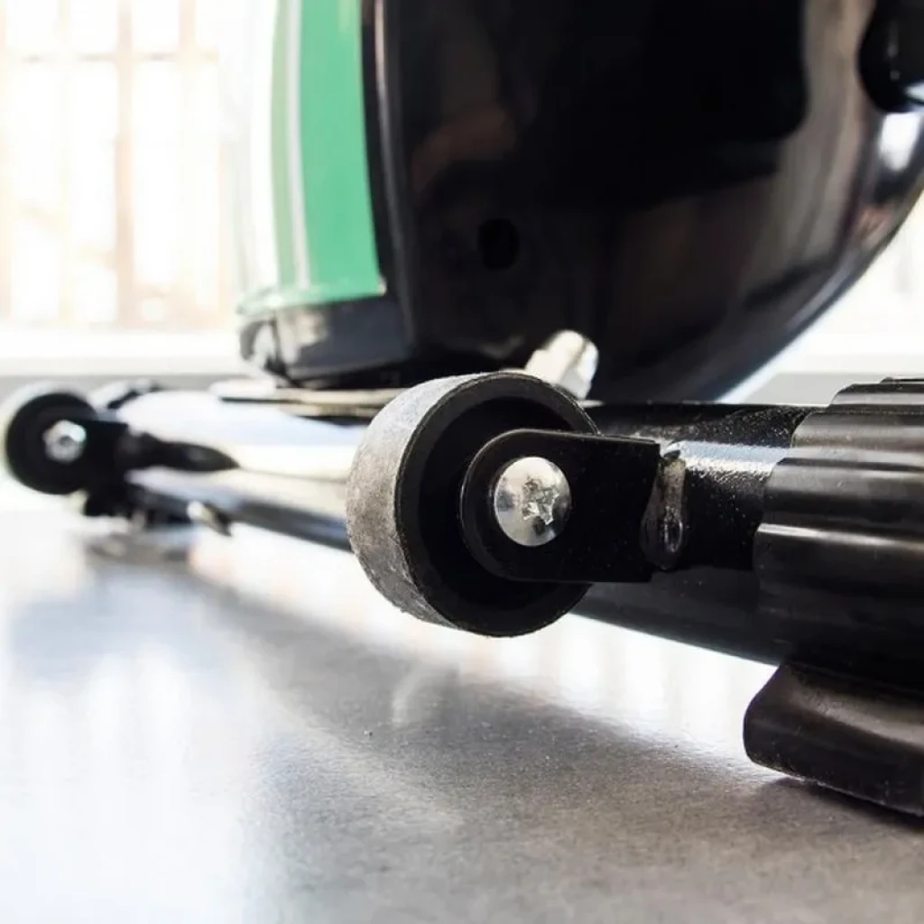 Rueda de transporte y base de la Bicicleta Estática Plegable X-Bike en metal negro, con perno visible y acabado robusto para fácil movilidad y estabilidad