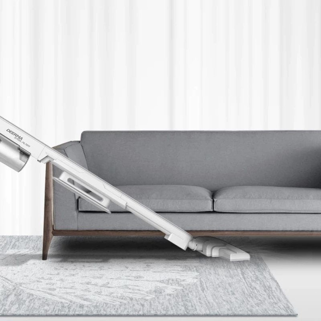 Deerma DX700 Handheld Vacuum Cleaner en color blanco, diseño delgado tipo escoba con tubo largo y cabezal plano limpiando alfombra junto a sofá gris
