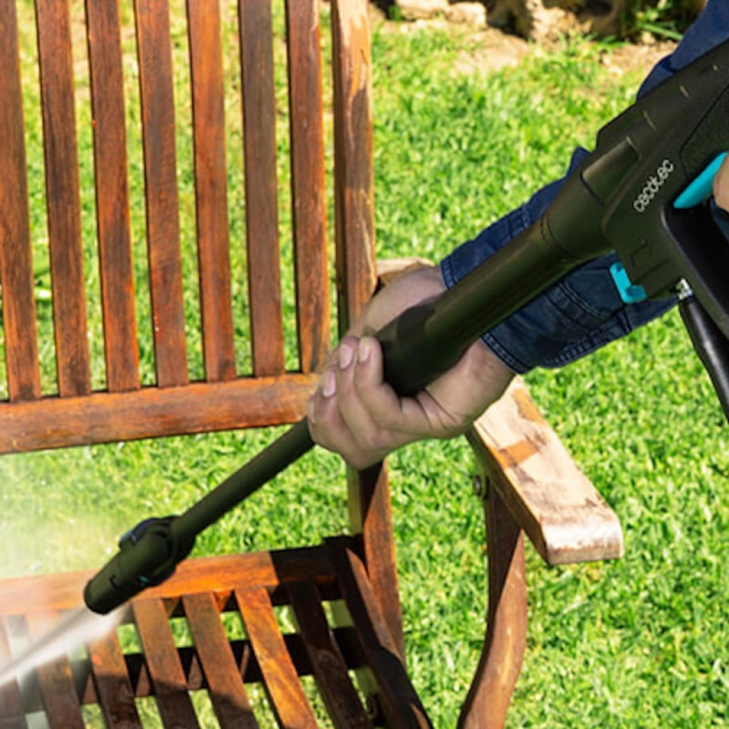 Lanza de la hidrolimpiadora Cecotec HidroBoost 1400 EasyMove limpiando una silla de madera con chorro a presión, diseño ergonómico en negro con detalles