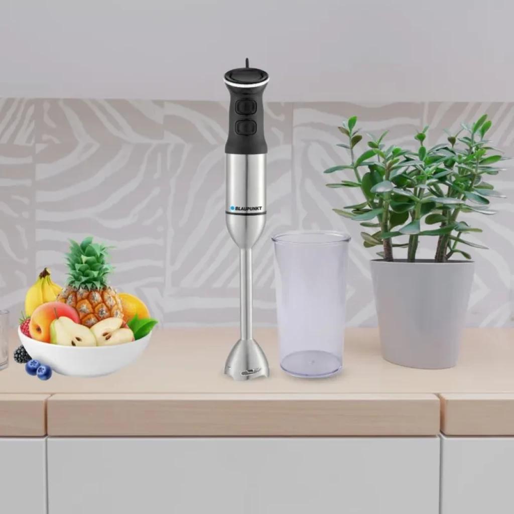 Blaupunkt BP4006 1200W batidora de mano en acero inoxidable con cuerpo plateado y negro, varilla desmontable y vaso medidor transparente junto a frutas