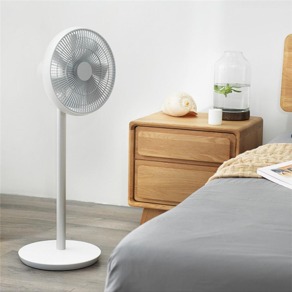 Ventilador de pie blanco con base redonda estable, rejilla circular gris y altura media junto a mesita de madera en dormitorio minimalista Desprecintado