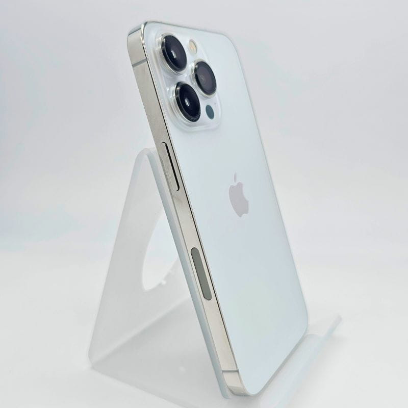 iPhone 13 Pro 256 Go Argent Renewed État Excellent avec dos verre blanc, bords plats acier brillant et triple caméra pro sur support translucide