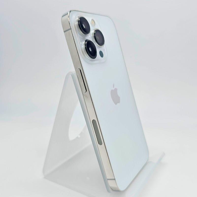iPhone 13 Pro 256 Go Argent Renewed État Excellent avec dos verre blanc, bords plats acier brillant et triple caméra pro sur support translucide