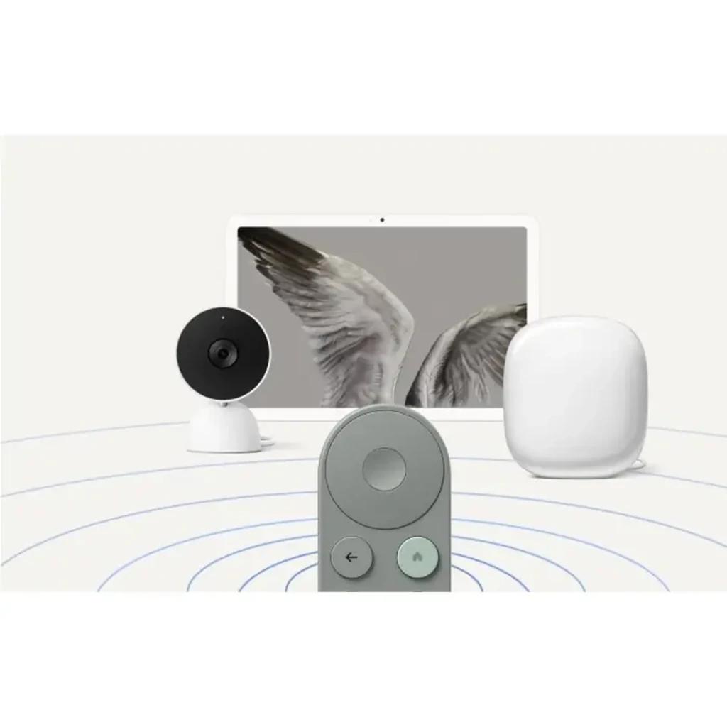 Controle remoto do Google TV Streamer 4K castanho em destaque, com botões circulares e setas; ao fundo, tablet, câmera de segurança e hub branco