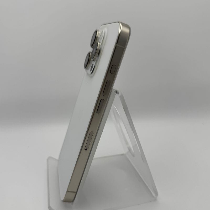 iPhone 15 Pro blanco titanio renovado: borde plano, marco metálico, triple cámara prominente, botones laterales visibles, acabado mate elegante.